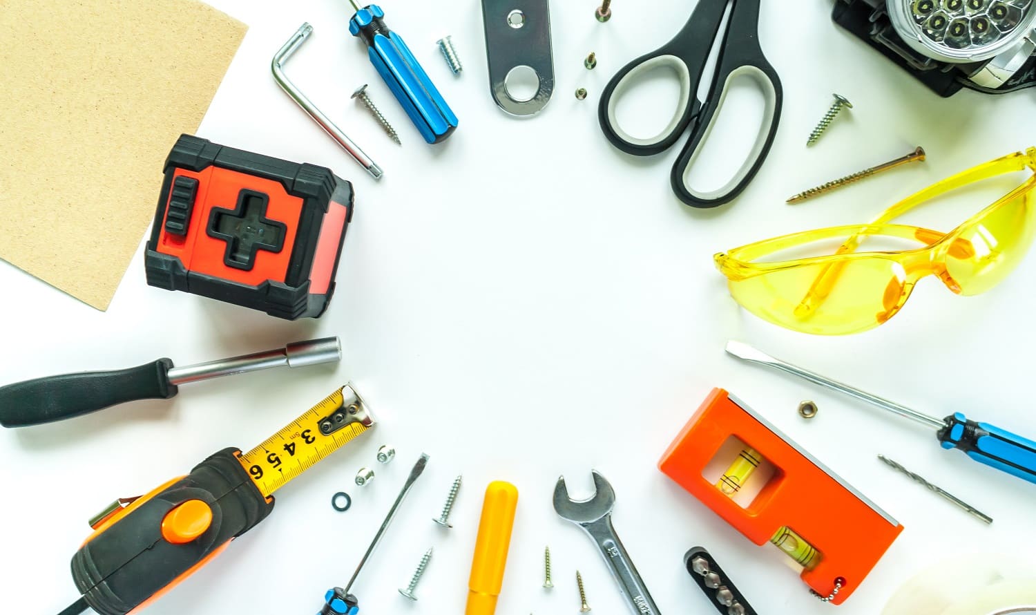 Round frame. Top view of working tools, wrench, screwdriver, level, tape measure, bolts, and safety glasses on a white background. Flat lay design.