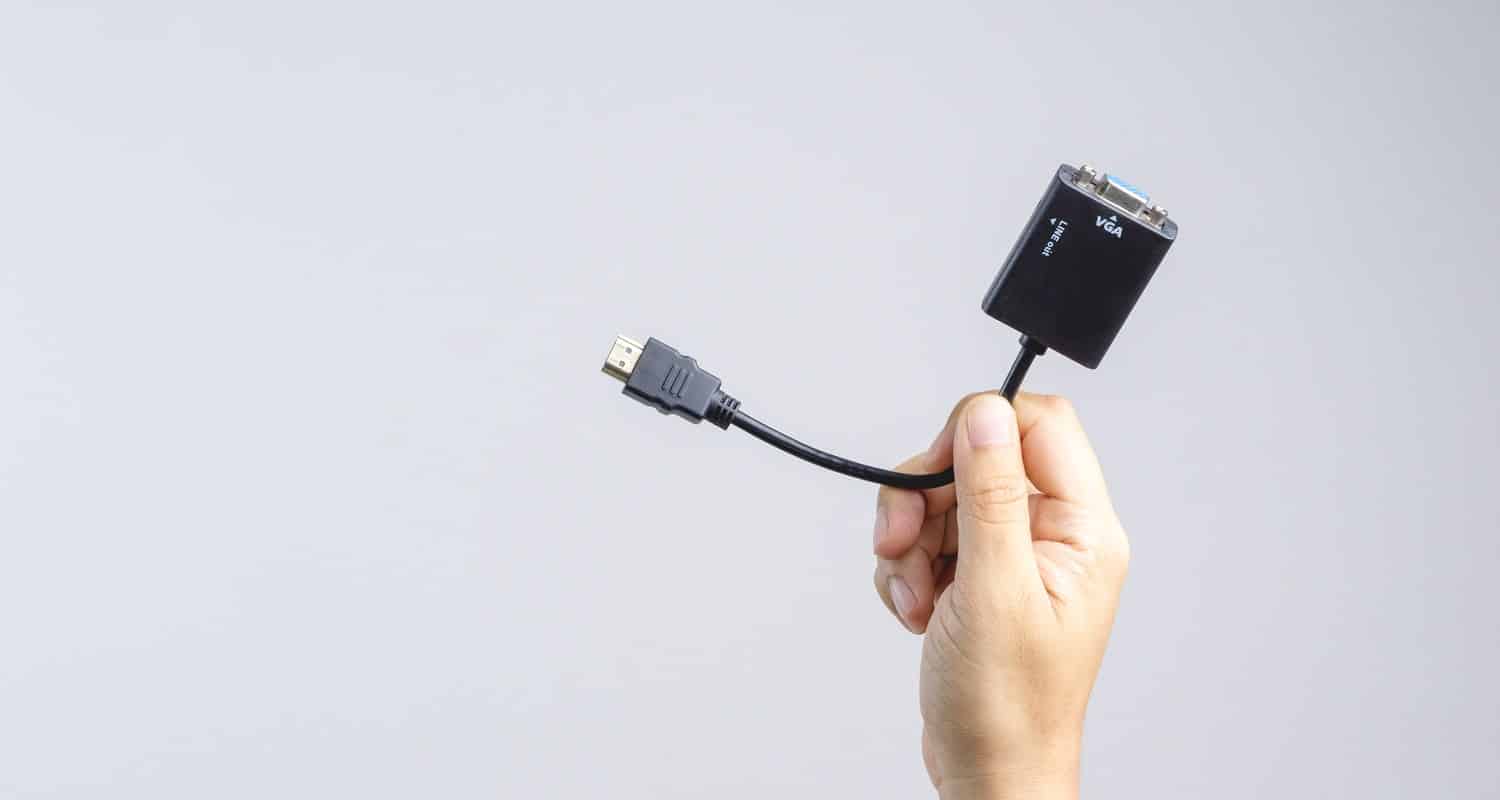 Hand holding adaptor hdmi to vga cable connector on white background