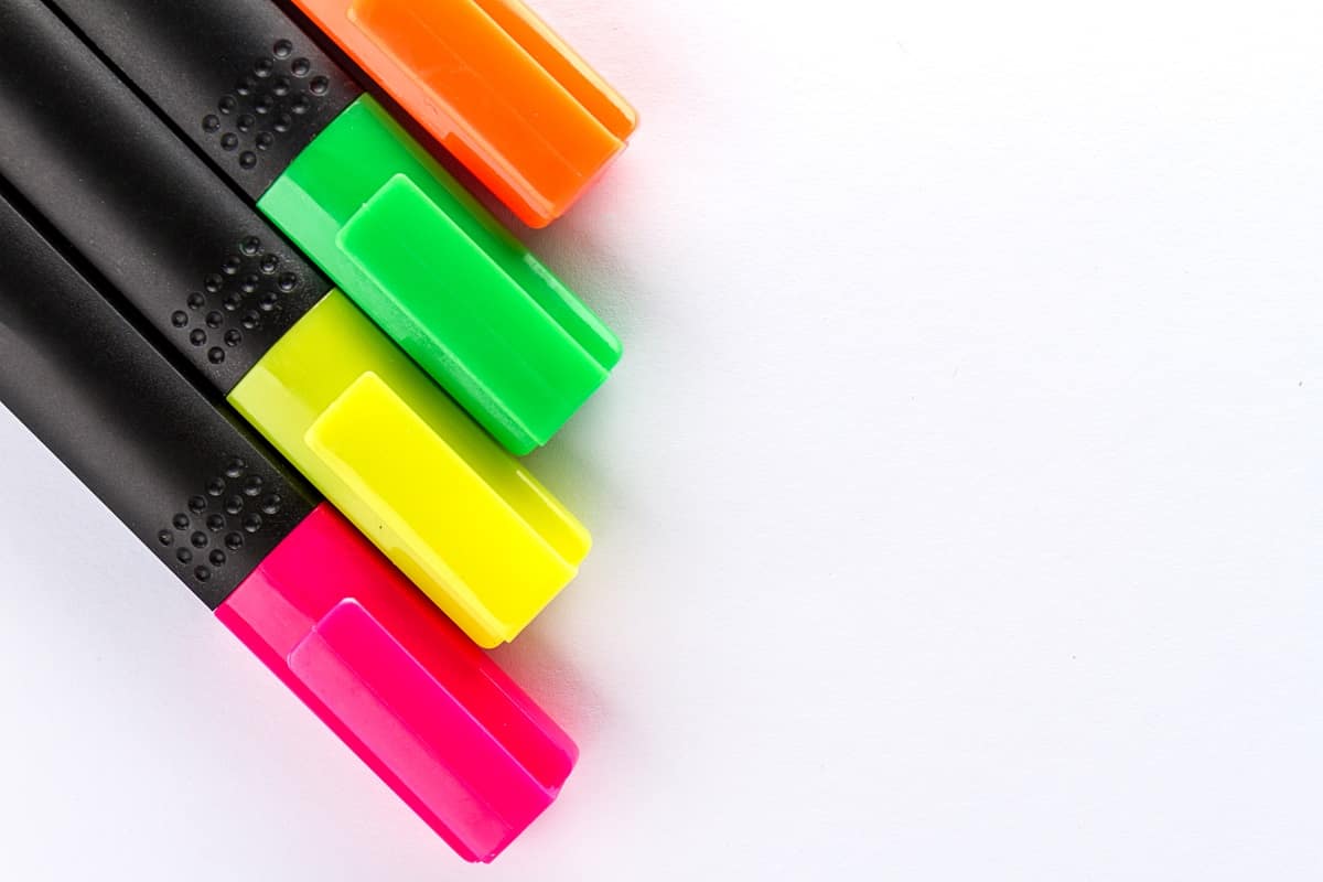 Different colorful markers with office accessories on white office table. Top view. Work study concept.