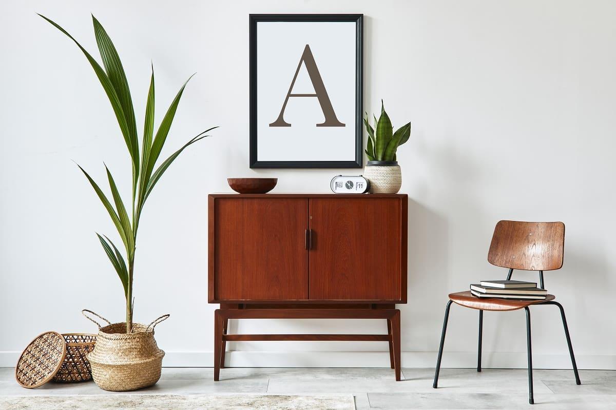 Stylish interior design of living room with wooden retro commode. Personalized wall art.