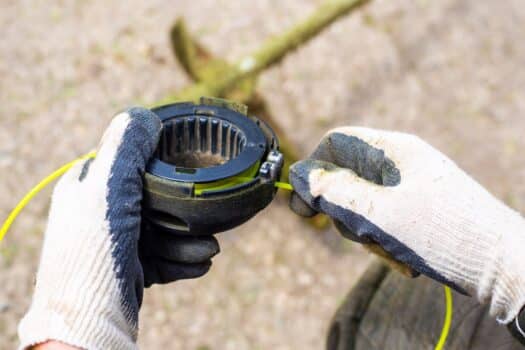 The gardener winds the fishing line around the head of the trimmer. Replacing consumables for lawn mowers. How to string a weed eater final words.